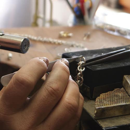 woman closing jump rings on jewelry